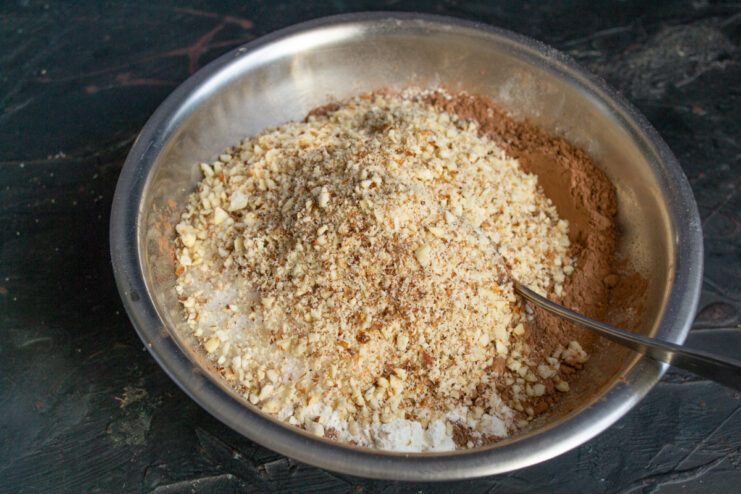 Stirring in the Almond Crumbs Crushed almonds mixed into flour and cocoa powder in a bowl