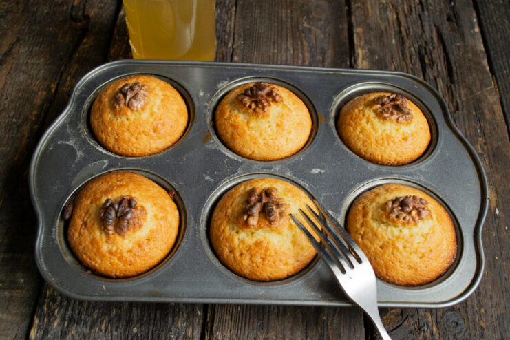 Preparing for the syrup soak Piercing hot baked muffins with a fork to absorb syrup