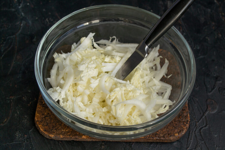 Shredding The Cabbage Thinly sliced napa cabbage in a clear glass bowl