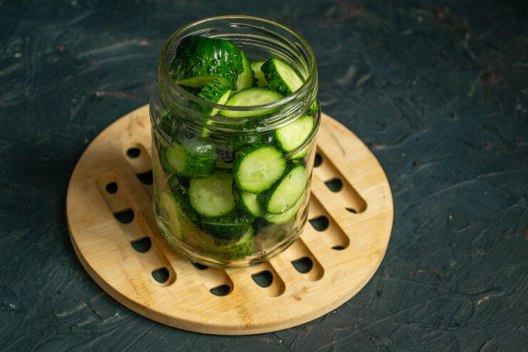 Sliced cucumber rounds loosely packed into a sterilized glass canning jar