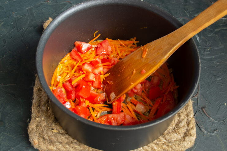 Incorporating diced tomatoes Peeled and diced tomatoes added to the vegetable mix.