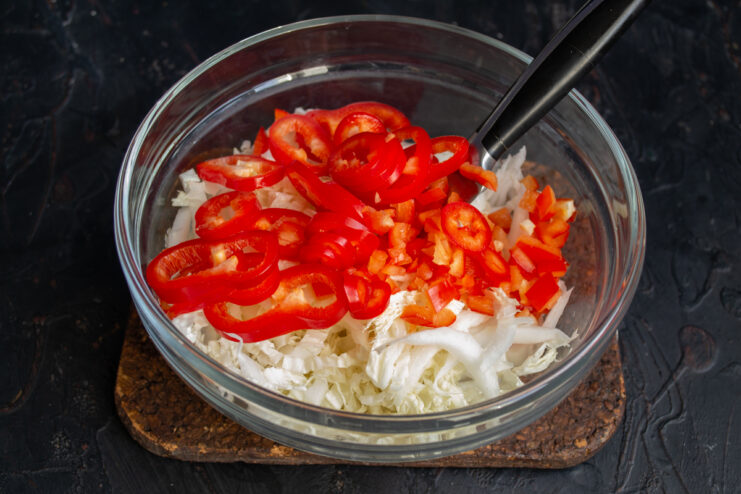 Adding The Vegetables Diced tomatoes and sliced red bell pepper in a salad bowl