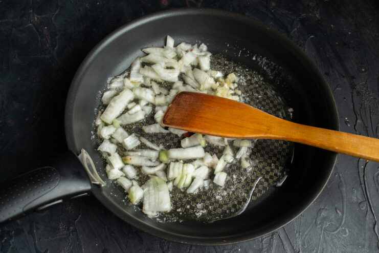 Sautéing the aromatics Chopped onions and garlic cooking in a skillet.