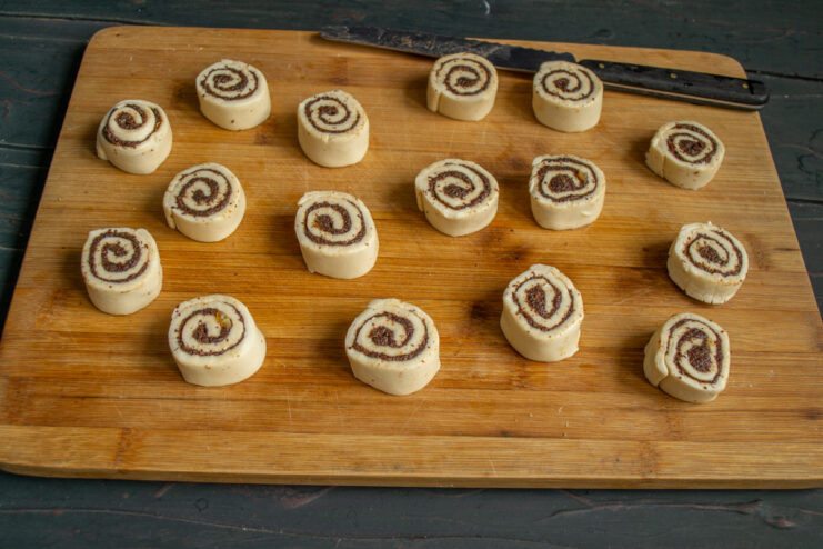 Slicing the pinwheels Slicing the poppy seed pastry log into individual rounds with a sharp knife.
