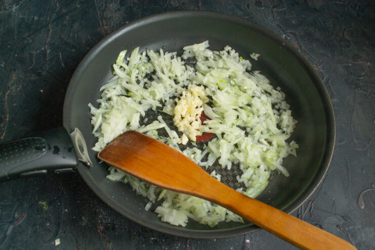 Sautéing onions in oil and butter Finely chopped onion and garlic sautéing in a hot skillet