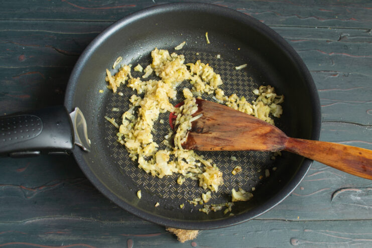 Sautéing finely diced onions in a skillet
