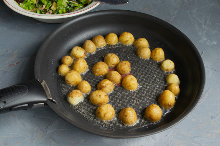 Sautéing the Potatoes Sautéing halved baby potatoes in a skillet