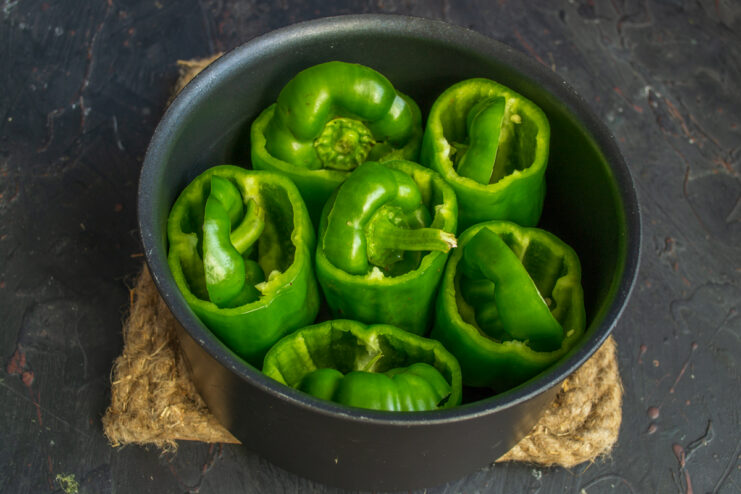 Preparing the bell peppers Hollowed green bell peppers standing upright in a cooking pot