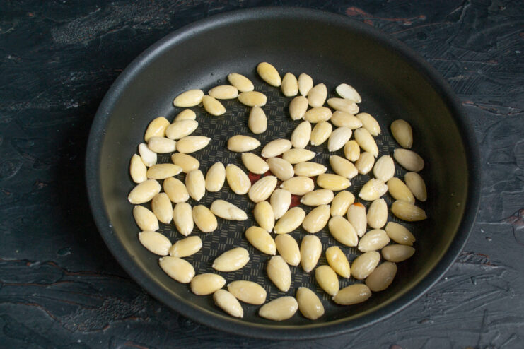 Peeled white almonds drying in a hot skillet