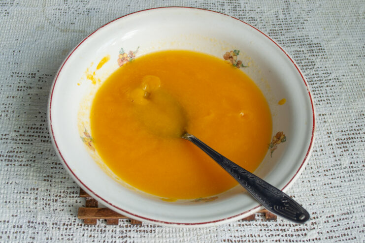 Smooth apricot base Smooth, thick, and vibrant orange apricot puree in a mixing bowl.
