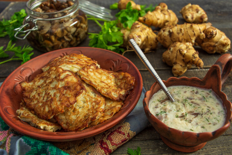 Golden Jerusalem artichoke fritters topped with a creamy mushroom sauce