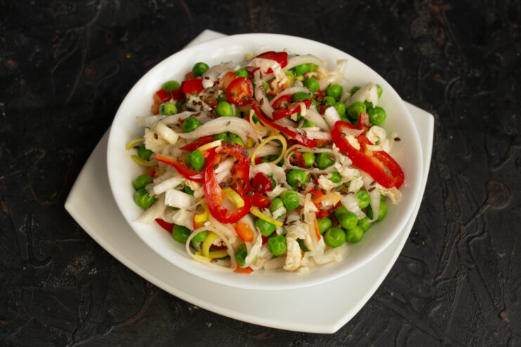Serving The Salad Vegetable salad with green peas served in a white bowl