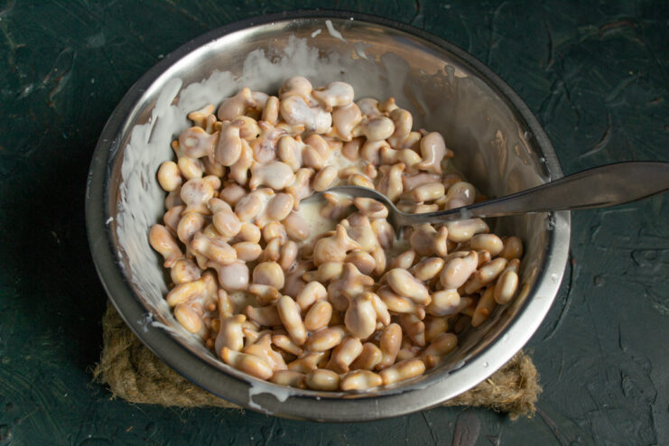 Coating the crackers Stirring the small crackers and cream mixture together with a spoon