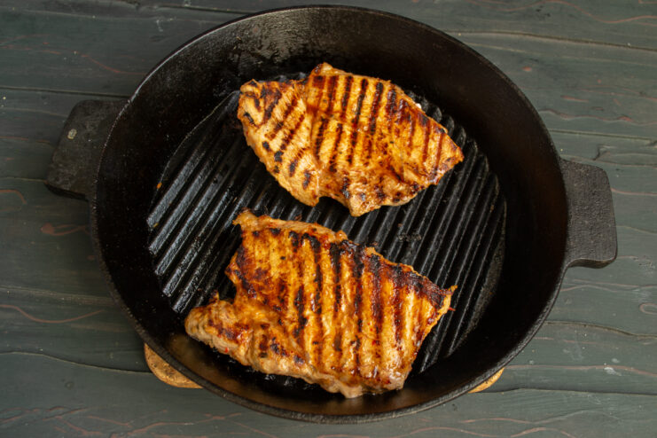 Perfect Grill Marks on Meat Flipped pork pieces with golden-brown grill marks.