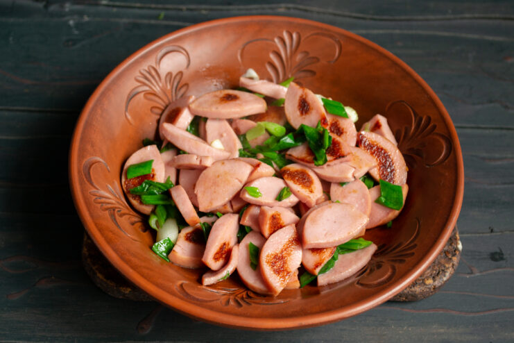 Assembling The Meat Layer Base layer of sautéed sausages in a deep bowl