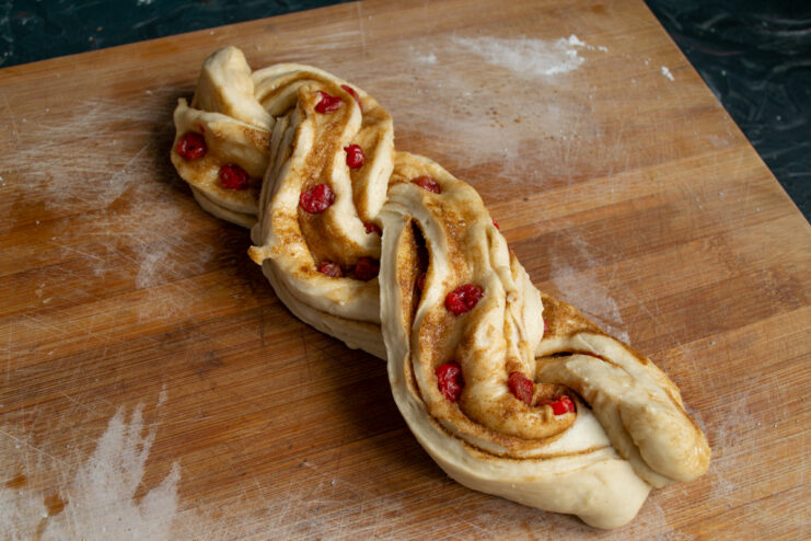 Braiding the babka Two halves of filled dough log twisted together into a braid