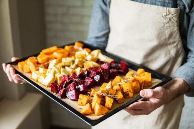 Roasted root vegetable cubes on a baking tray Diced carrots and beets roasted to a golden brown on a baking sheet, showcasing proper caramelization techniques.
