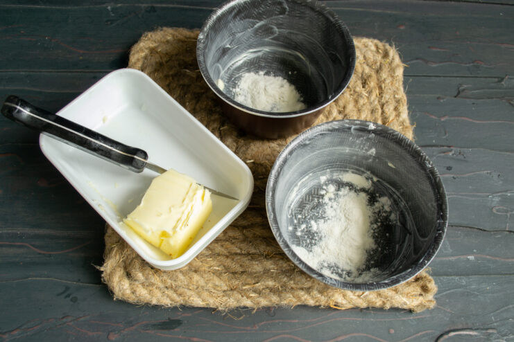 Preparing the molds Greasing and flouring small ramekins for baking