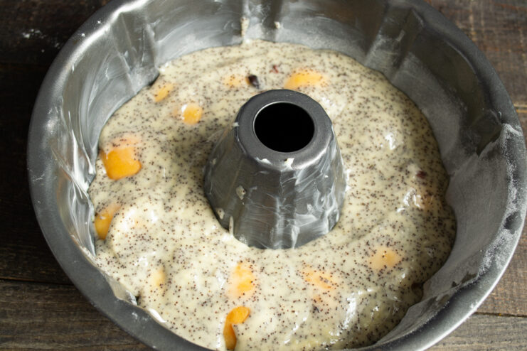 Adding the final batter layer Covering the fresh apricots with the remaining layer of batter