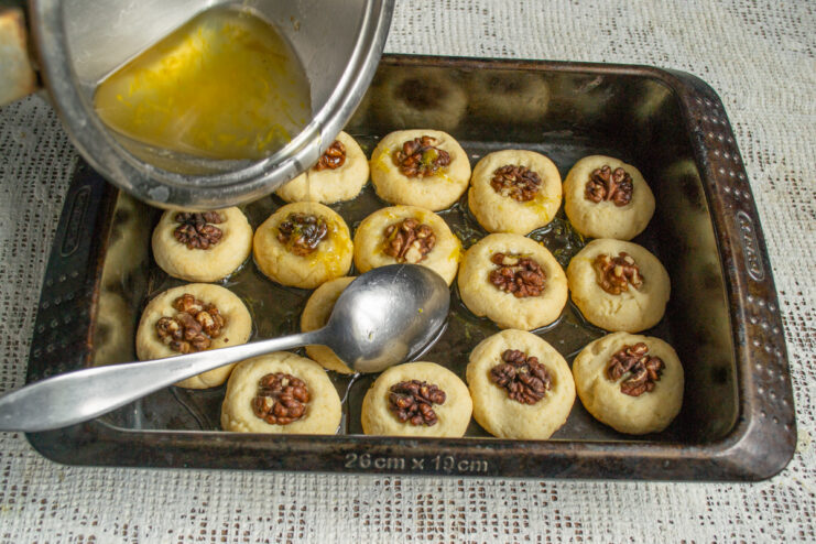 Soaking in syrup Pouring lime syrup over hot baked cookies in a dish