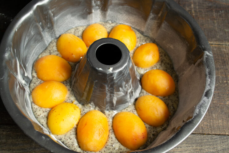 Arranging the apricot layer Fresh apricot halves arranged on top of the batter
