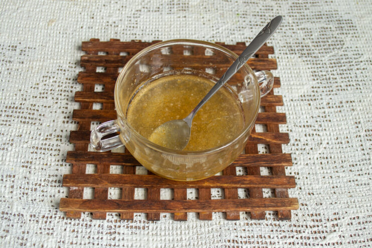 Soaking the gelatin Powdered gelatin blooming in ice-cold water in a clear glass bowl.