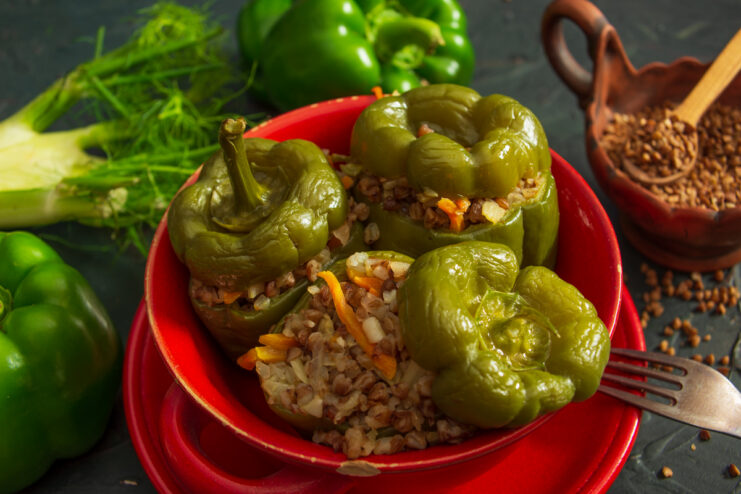 Appetizing vegan stuffed pepper with buckwheat and vegetables in a red bowl