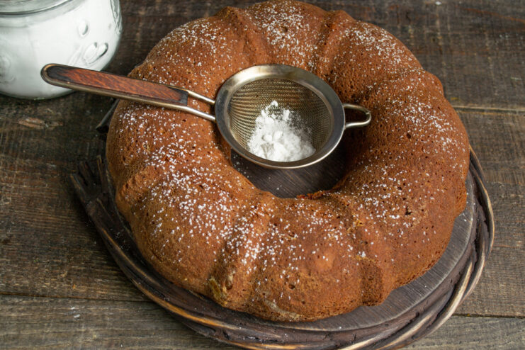 Dusting with powdered sugar Dusting the poppy seed cake with powdered sugar through a sieve
