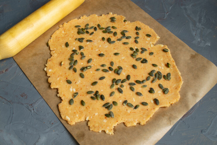 Decorating with pumpkin seeds Scattering pumpkin seeds evenly over the rolled dough