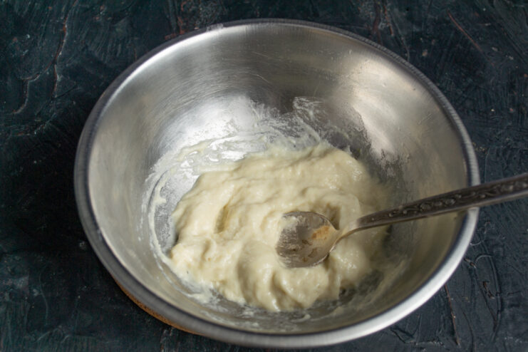 Mixing dumpling dough to a thick consistency Preparing thick sticky dough for dumplings in a mixing bowl