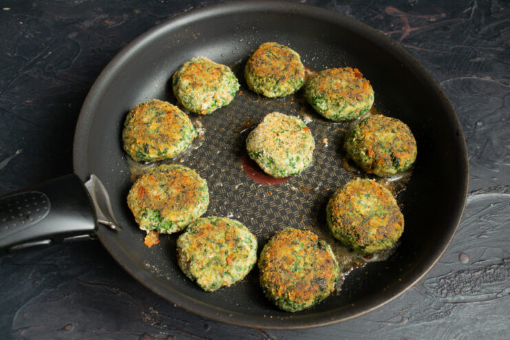Frying green vegetable patties in a hot oiled skillet