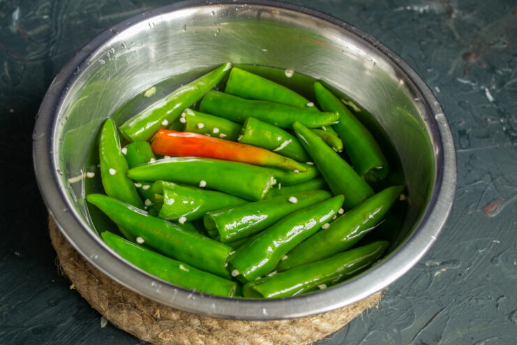 Rinsing the peppers Rinsing deseeded green chili peppers in a bowl of water