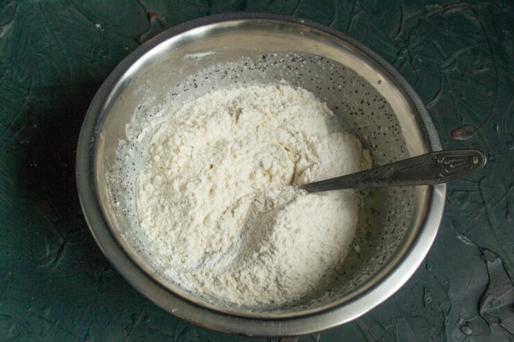 Wheat flour and baking powder folded into the wet poppy seed mixture.
