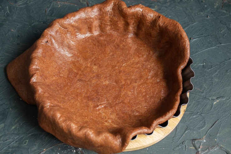 Placing the Dough in the Pan Rolled chocolate dough fitted into a round metal baking pan