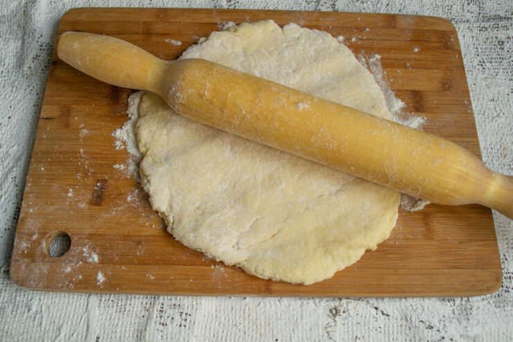 Rolling out the dough Rolling out the dough on a wooden surface with a rolling pin
