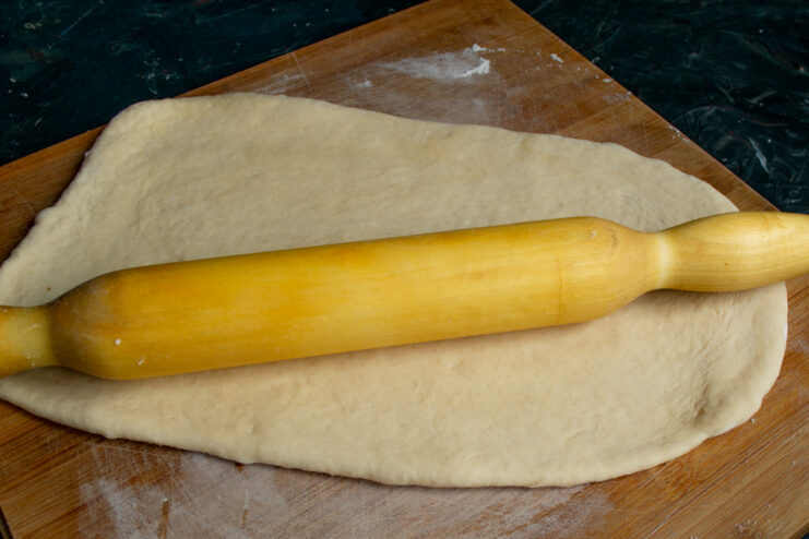 Rolling out the dough Rolling yeast dough into a rectangle using a wooden rolling pin