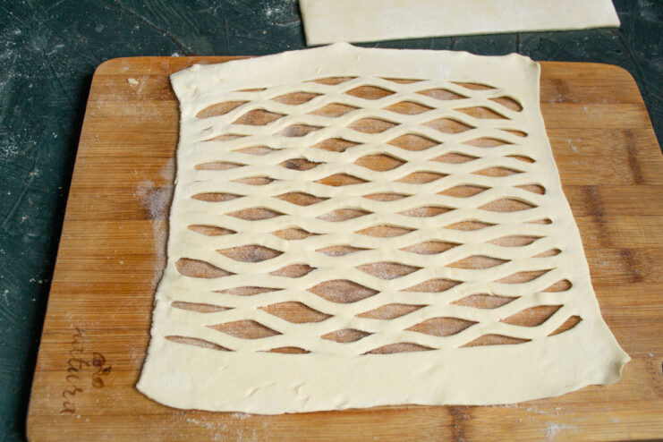 Creating the pastry lattice Stretching scored puff pastry dough to form a lattice pattern