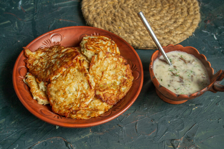 Plating and serving Plated Jerusalem artichoke fritters covered in hot mushroom sauce
