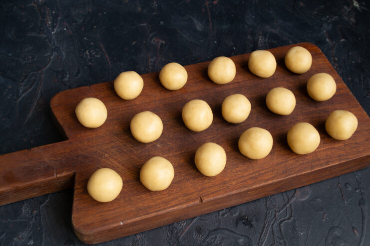 Forming dough balls Shortbread dough balls arranged on a wooden board.