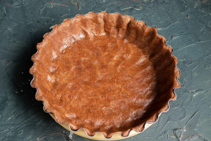 Prepping the Crust for Baking Chocolate dough in a baking pan with trimmed edges, pricked with a fork for even baking