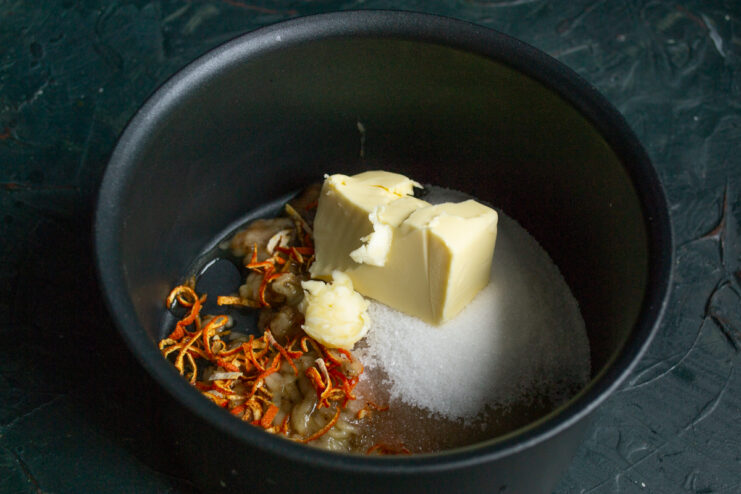 Adding butter and sugar Butter and sugar added to the grated banana