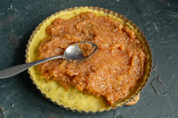 Filling the pie with apples Thick layer of apple filling spread over the raw pastry crust in a pan