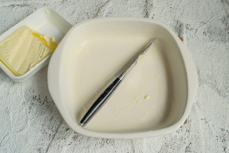 Preparing The Baking Dish Greasing an oven-safe baking dish with butter