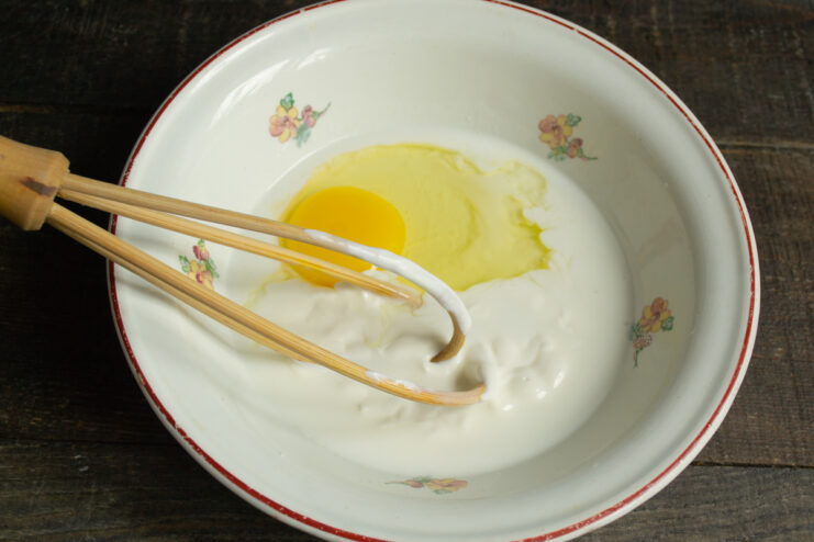 Preparing the liquid base Mixing kefir, sour cream, and an egg in a deep bowl