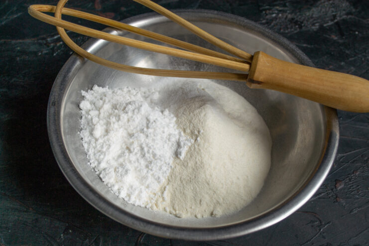 Whisking all-purpose flour, powdered sugar, and baking powder in a mixing bowl.