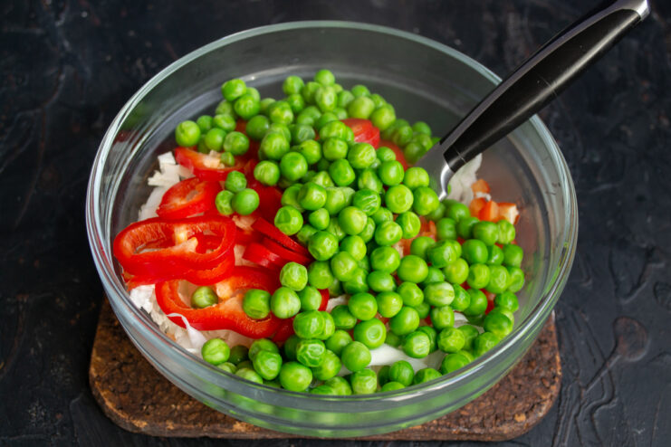 Adding The Peas Tossing fresh vegetables with vibrant green peas