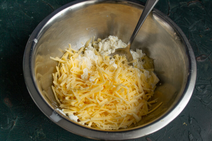 Mixing the cheese base Mixing ricotta and grated Gouda cheese in a bowl