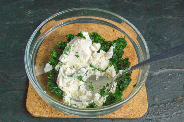 Mixing bright green spinach with soft ricotta cheese in a bowl
