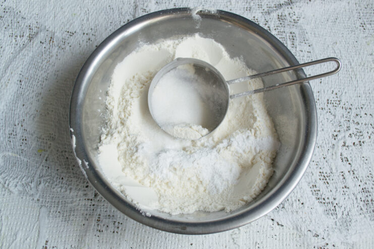 Mixing the Dry Ingredients Whisking flour, sugar, and baking powder in a metal mixing bowl.