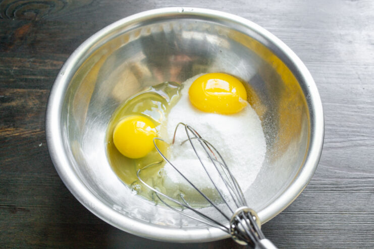 Whisking Eggs And Sugar Whisking eggs and sugar in a metal mixing bowl